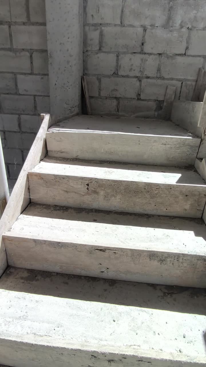 Detalle de las tapagradas: encofrado de madera todavia puesto sobre los peldanos de una escalera de hormigon